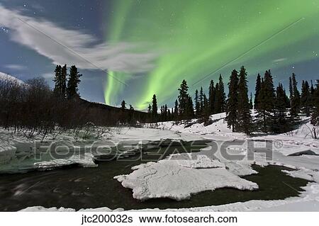 Stock Photograph - Aurora borealis over creek, Yukon, Canada.. Fotosearch