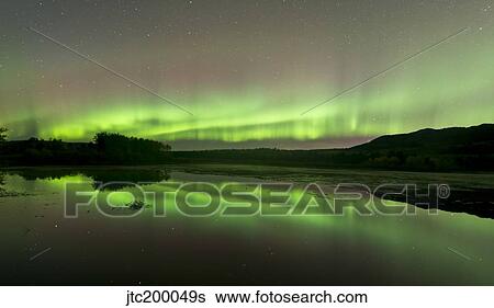 Stock Photograph - Aurora borealis over Fish Lake, Whitehorse, Yukon, Canada.. Fotosearch