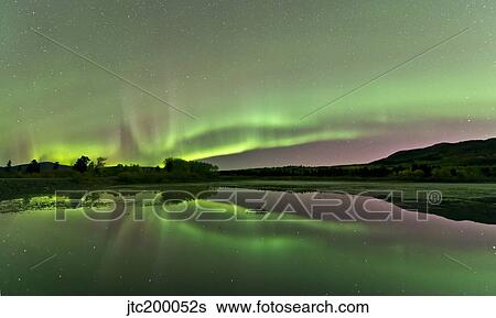 Stock Photograph - Aurora borealis over Fish Lake, Whitehorse, Yukon, Canada.. Fotosearch