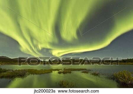 Stock Photograph - Aurora borealis over Fish Lake, Yukon, Canada.. Fotosearch
