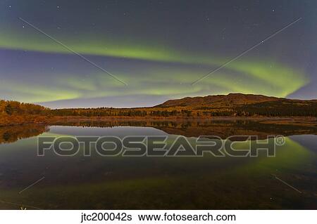 Stock Photograph - Aurora borealis over Fish Lake, Yukon, Canada.. Fotosearch