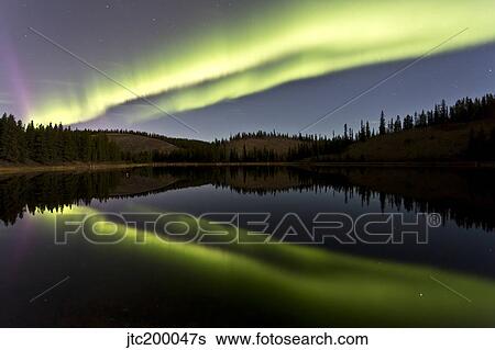 Stock Photograph - Aurora borealis over Hidden Lake, Yukon, Canada.. Fotosearch