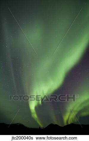 Stock Photograph - Aurora borealis over mountain, Fish Lake, Yukon, Canada.. Fotosearch