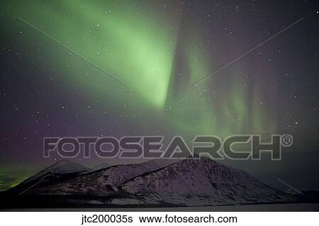 Aurora borealis over mountain range, Carcross, Yukon, Canada. View Large Photo Image Stock Photograph - Aurora borealis over mountain range, Carcross, Yukon, Canada.. Fotosearch
