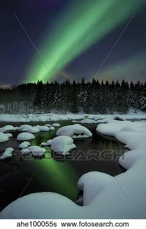 Stock Photograph - Aurora Borealis over Tennevik River in Troms County, Norway.. Fotosearch
