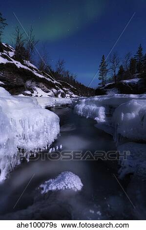 Stock Photograph - Aurora Borealis over Tennevik River, Troms, Norway.. Fotosearch