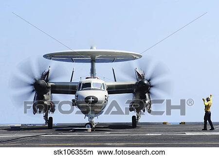 Aviation Boatswain's Mate directs an E-2C Hawkeye on the flight deck. View Large Photo Image Picture - Aviation Boatswain's Mate directs an E-2C Hawkeye on the flight deck.. Fotosearch