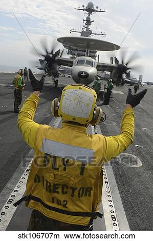 Picture - Aviation Boatswain's Mate directs an E-2C Hawkeye aboard USS John C. Stennis.. Fotosearch