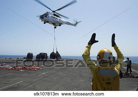 Aviation Boatswain's Mate directs an SA-330J Puma helicopter. View Large Photo Image Picture - Aviation Boatswain's Mate directs an SA-330J Puma helicopter.. Fotosearch