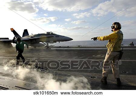 Aviation Boatswain's Mate ensures an F/A-18C Hornet is cleared for launch. View Large Photo Image Picture - Aviation Boatswain's Mate ensures an F/A-18C Hornet is cleared for launch.. Fotosearch