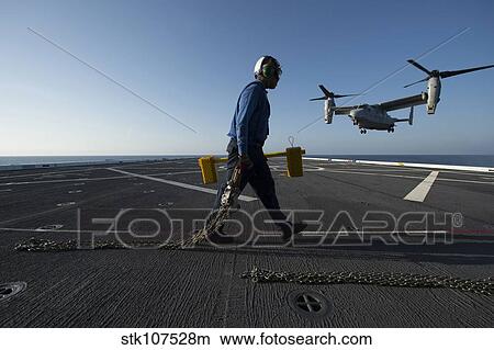 Aviation Boatswain's Mate prepares to chock and chain an MV-22 Osprey. View Large Photo Image Picture - Aviation Boatswain's Mate prepares to chock and chain an MV-22 Osprey.. Fotosearch
