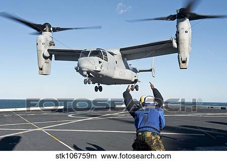 Picture - Aviation Boatswain's Mate signals an MV-22 Osprey for liftoff.. Fotosearch