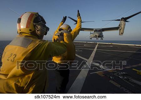 Aviation Boatswain's Mates direct an MV-22 Osprey on the flight deck. View Large Photo Image Picture - Aviation Boatswain's Mates direct an MV-22 Osprey on the flight deck.. Fotosearch