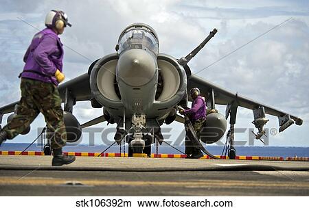 Aviation boatswain's mates refuel an AV-8B Harrier jet aircraft. View Large Photo Image Picture - Aviation boatswain's mates refuel an AV-8B Harrier jet aircraft.. Fotosearch