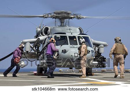 Aviation Boatswain's Mate's run to refuel an MH-60S Sea Hawk helicopter. View Large Photo Image Picture - Aviation Boatswain's Mate's run to refuel an MH-60S Sea Hawk helicopter.. Fotosearch