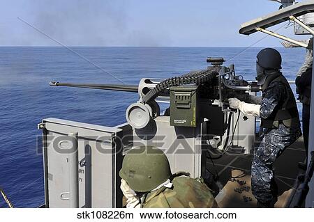Picture - Aviation Ordnanceman fires a 25mm machine gun.. Fotosearch