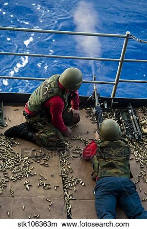 Aviation Ordnanceman fires a M240 machine gun aboard USS John C. Stennis. View Large Photo Image Picture - Aviation Ordnanceman fires a M240 machine gun aboard USS John C. Stennis.. Fotosearch