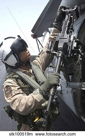 Aviation Warfare Systems Operator safety checks a. 50-caliber machine gun on an SH-60F Seahawk. View Large Photo Image Picture - Aviation Warfare Systems Operator safety checks a. 50-caliber machine gun on an SH-60F Seahawk.. Fotosearch