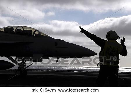 Aviations Boatswain's Mate directs an F/A-18E Super Hornet. View Large Photo Image Picture - Aviations Boatswain's Mate directs an F/A-18E Super Hornet.. Fotosearch