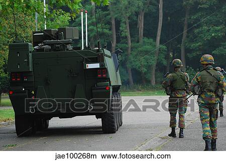 Belgian Infantry soldiers walk alongside the Piranha IIC armoured infantry vehicle. View Large Photo Image Picture - Belgian Infantry soldiers walk alongside the Piranha IIC armoured infantry vehicle.. Fotosearch