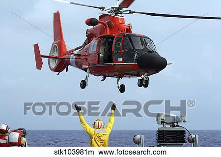 Boatswain Mate directs a HH-65A Dolphin aboard the guided-missile destroyer USS Russell. View Large Photo Image Picture - Boatswain Mate directs a HH-65A Dolphin aboard the guided-missile destroyer USS Russell.. Fotosearch