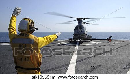 Boatswain's Mate directs a CH-46 Sea Knight helicopter aboard USS Germantown. View Large Photo Image Picture - Boatswain's Mate directs a CH-46 Sea Knight helicopter aboard USS Germantown.. Fotosearch