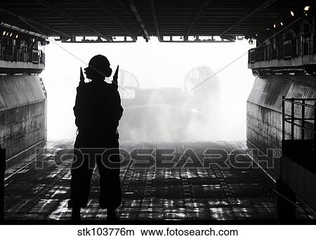 Boatswain's Mate directs a landing craft air cushion as it approaches USS Kearsarge. View Large Photo Image Picture - Boatswain's Mate directs a landing craft air cushion as it approaches USS Kearsarge.. Fotosearch