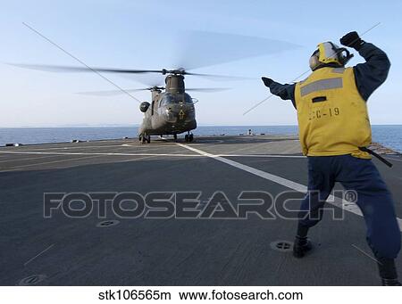 Boatswain's Mate signals to an Army CH-47 Chinook helicopter. View Large Photo Image Picture - Boatswain's Mate signals to an Army CH-47 Chinook helicopter.. Fotosearch