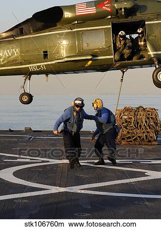 Boatswain's Mates move away after connecting a hoisting sling onto an SH-60F Sea Hawk. View Large Photo Image Picture - Boatswain's Mates move away after connecting a hoisting sling onto an SH-60F Sea Hawk.. Fotosearch
