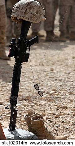 Boots, a helmet, rifle and dog tags serve as a representation of the memory of a soldier. View Large Photo Image Picture - Boots, a helmet, rifle and dog tags serve as a representation of the memory of a soldier.. Fotosearch