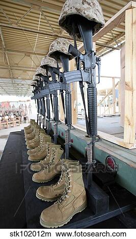 Boots, rifles, dog tags, and protective helmets stand in solitude to honor fallen soldiers. View Large Photo Image Picture - Boots, rifles, dog tags, and protective helmets stand in solitude to honor fallen soldiers.. Fotosearch