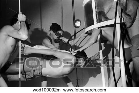 BUD/S dive tower instructors transfer a student from a roving bell in preparation for swimming ascent training. View Large Photo Image Picture - BUD/S dive tower instructors transfer a student from a roving bell in preparation for swimming ascent training.. Fotosearch