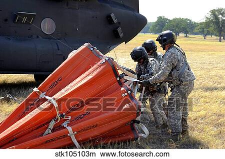 CH-47 Chinook helicopter crew prepare to install the Bambi Bucket on the aircraft. View Large Photo Image Picture - CH-47 Chinook helicopter crew prepare to install the Bambi Bucket on the aircraft.. Fotosearch