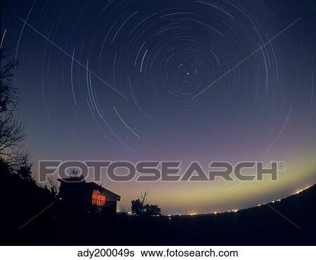 Circumpolar star trails with a faint aurora over horizon, Alberta, Canada. View Large Photo Image Stock Photograph - Circumpolar star trails with a faint aurora over horizon, Alberta, Canada.. Fotosearch
