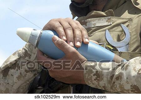 Picture - Close-up view of a soldier cradling a munition.. Fotosearch