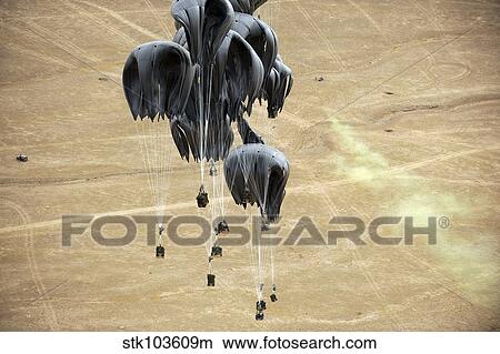 Container delivery system bundles parachute down to a drop zone marked by warfighters on the ground in Afghanistan. View Large Photo Image Picture - Container delivery system bundles parachute down to a drop zone marked by warfighters on the ground in Afghanistan.. Fotosearch