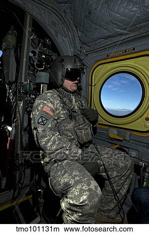 Crew chief looking out the window of a CH-47 Chinook. View Large Photo Image Picture - Crew chief looking out the window of a CH-47 Chinook.. Fotosearch