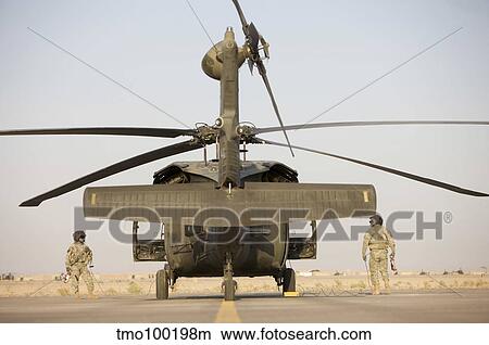 Crew Chiefs stand beside their UH-60L Black Hawk helicopter. View Large Photo Image Picture - Crew Chiefs stand beside their UH-60L Black Hawk helicopter.. Fotosearch