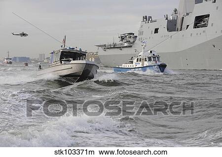 Crews from the coast guard and police departments escort USS New York as it sails into New York Harbor. View Large Photo Image Picture - Crews from the coast guard and police departments escort USS New York as it sails into New York Harbor.. Fotosearch