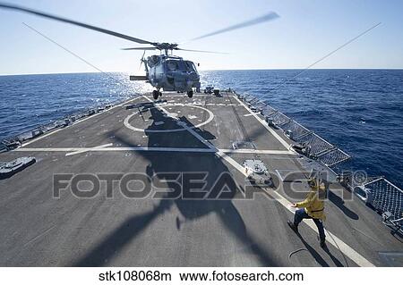 Cryptologic Technician directs an SH-60R Sea Hawk helicopter. View Large Photo Image Picture - Cryptologic Technician directs an SH-60R Sea Hawk helicopter.. Fotosearch
