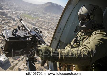 Czech Air Force door gunner scans the ground from a Mi-17 helicopter. View Large Photo Image Picture - Czech Air Force door gunner scans the ground from a Mi-17 helicopter.. Fotosearch