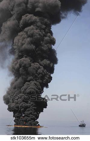 Dark clouds of smoke and fire emerge as oil burns during a controlled fire in the Gulf of Mexico. View Large Photo Image Picture - Dark clouds of smoke and fire emerge as oil burns during a controlled fire in the Gulf of Mexico.. Fotosearch