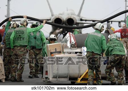 Delivery crew lift a fuel hose to help other Sailors move mail and supplies across the flight deck. View Large Photo Image Picture - Delivery crew lift a fuel hose to help other Sailors move mail and supplies across the flight deck.. Fotosearch