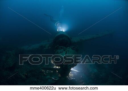 Stock Photograph - Diver exploring the wreck of a Japanese Navy Seaplane in Palau, Micronesia.. Fotosearch