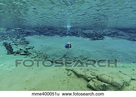 Stock Photograph - Diver in ultra clear water at The Silfra Lagoon, Iceland.. Fotosearch