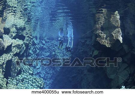 Dry suit divers entering the gin clear water of Silfra Crack, Iceland. View Large Photo Image Stock Photograph - Dry suit divers entering the gin clear water of Silfra Crack, Iceland.. Fotosearch