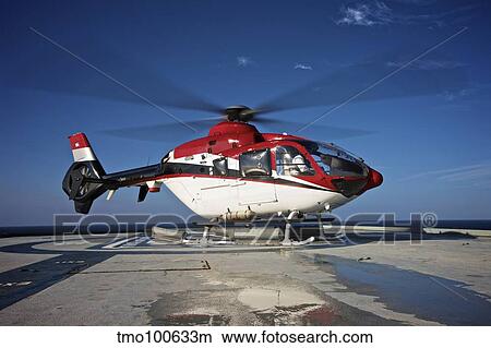 Picture - Eurocopter EC135 utility helicopter on the helipad of an oil rig.. Fotosearch