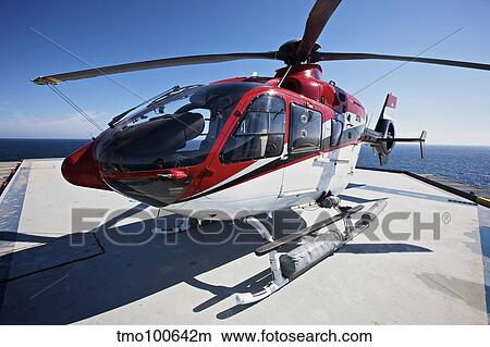 Eurocopter EC135 utility helicopter on the helipad of an oil rig. View Large Photo Image Picture - Eurocopter EC135 utility helicopter on the helipad of an oil rig.. Fotosearch