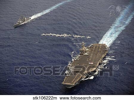 F/A-18 Hornets fly in formation over USS Abraham Lincoln and USS Cape St. George. View Large Photo Image Picture - F/A-18 Hornets fly in formation over USS Abraham Lincoln and USS Cape St. George.. Fotosearch