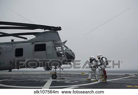 Firefighters approach a CH-46 Sea Knight to simulate a rescue. View Large Photo Image Picture - Firefighters approach a CH-46 Sea Knight to simulate a rescue.. Fotosearch